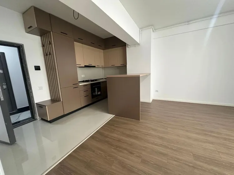 Hol cu cuier și bucătărie deschisă cu bar, în același decor